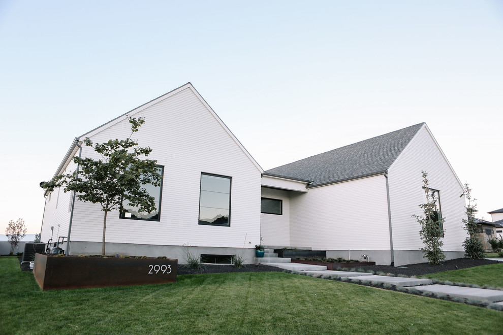 Стильный дизайн: двухэтажный, деревянный, белый частный загородный дом среднего размера в стиле модернизм с двускатной крышей и крышей из гибкой черепицы - последний тренд