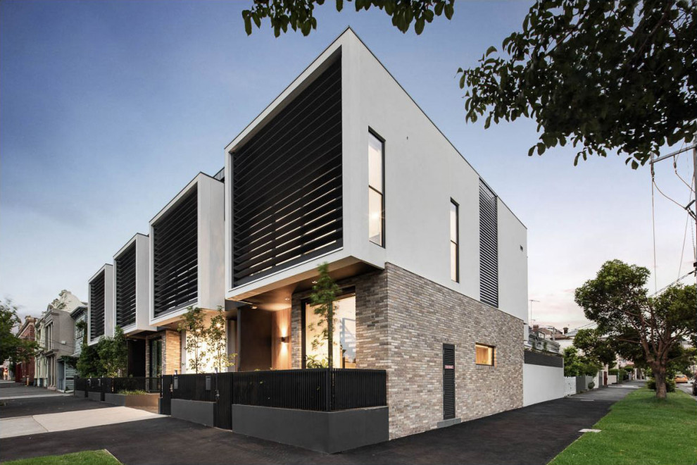 Imagen de fachada de casa pareada multicolor y negra minimalista de tamaño medio de tres plantas con revestimiento de ladrillo, tejado plano y tejado de metal