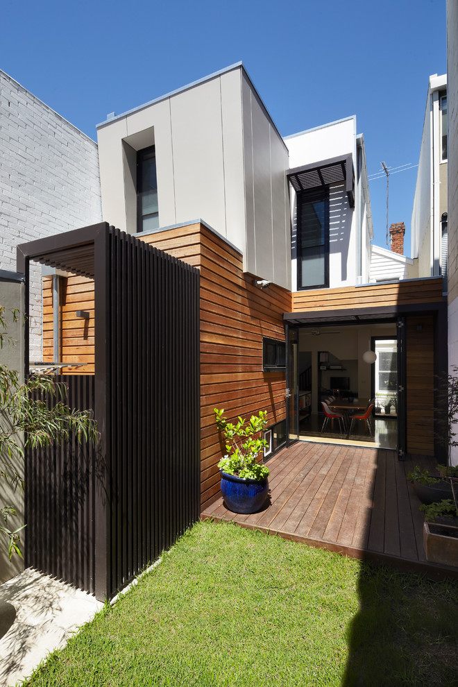 Inspiration pour une façade de maison marron design en bois de taille moyenne et à un étage avec un toit plat et un toit en métal.
