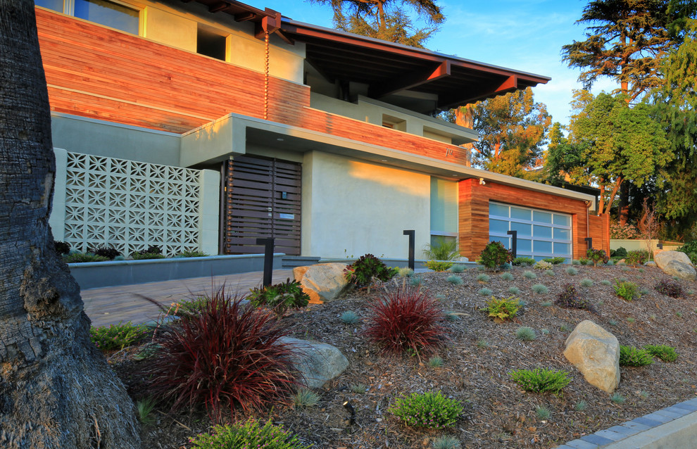 This is an example of a medium sized and gey contemporary two floor house exterior in Los Angeles with wood cladding.