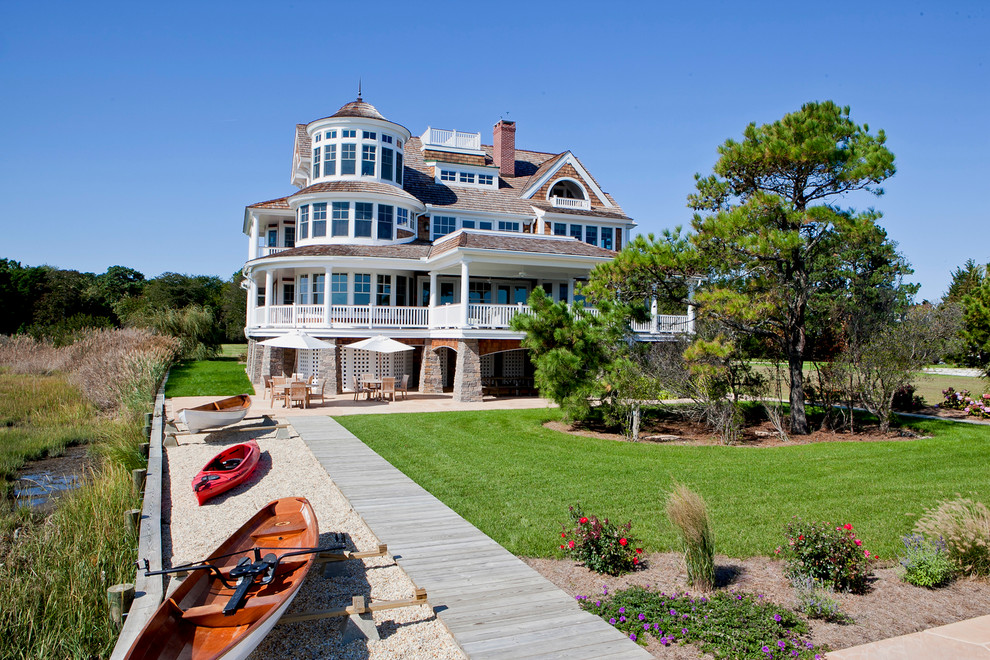 Inspiration for a large coastal brown three-story wood exterior home remodel in Other with a shingle roof