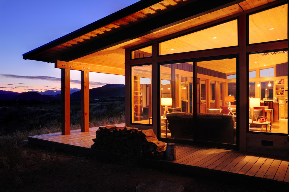 Cette image montre une petite façade de maison marron chalet de plain-pied avec un revêtement mixte et un toit en appentis.