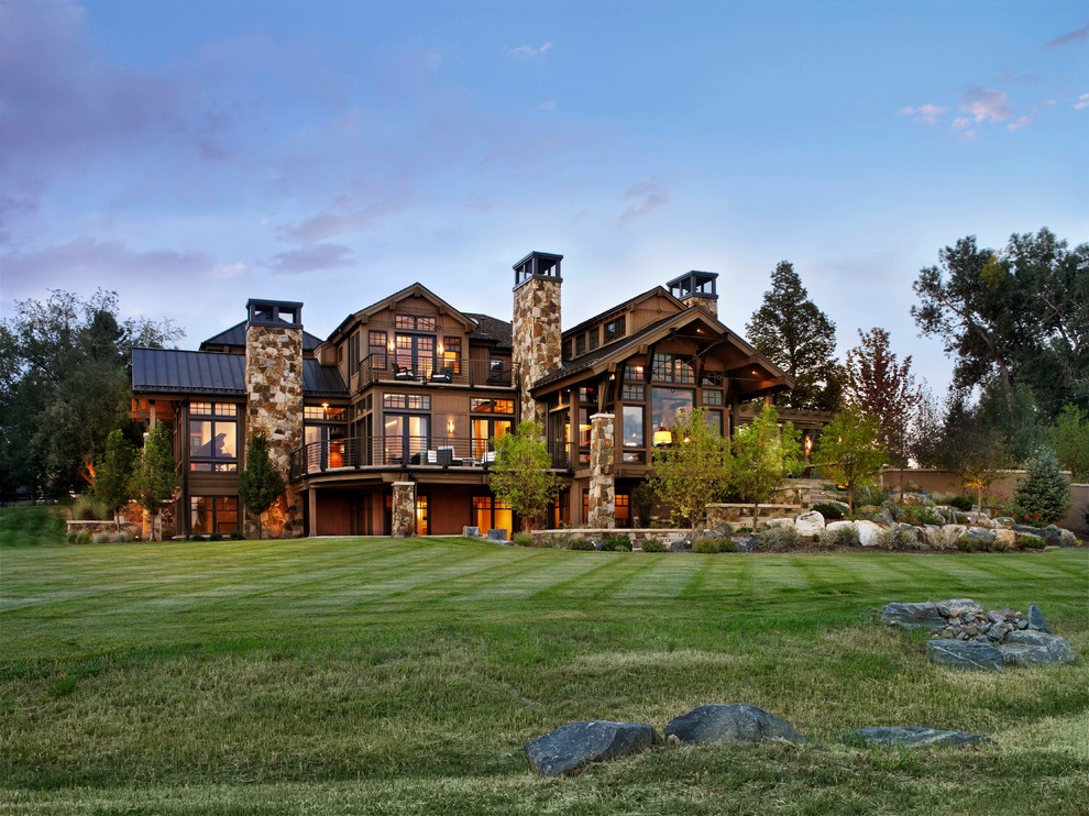 This is an example of a large rustic house exterior in Denver with three floors.
