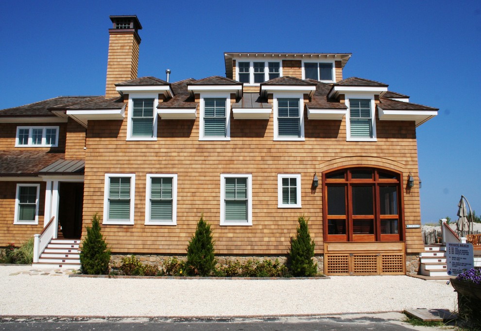 Immagine della villa grande marrone stile marinaro a tre piani con rivestimento in legno, tetto a padiglione e copertura a scandole