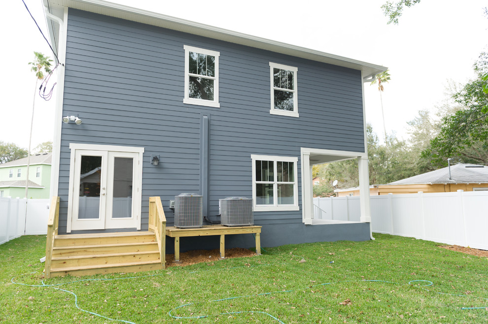 Modelo de fachada azul de estilo americano de tamaño medio de dos plantas con revestimiento de aglomerado de cemento y tejado a dos aguas