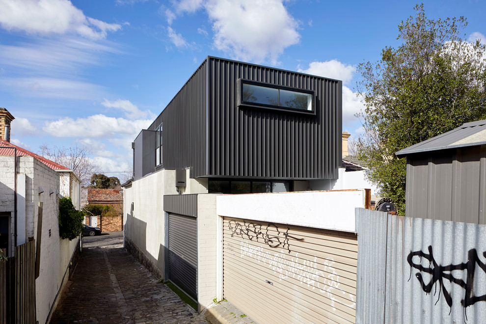 This is an example of a small and gey contemporary two floor detached house in Melbourne with metal cladding and a metal roof.