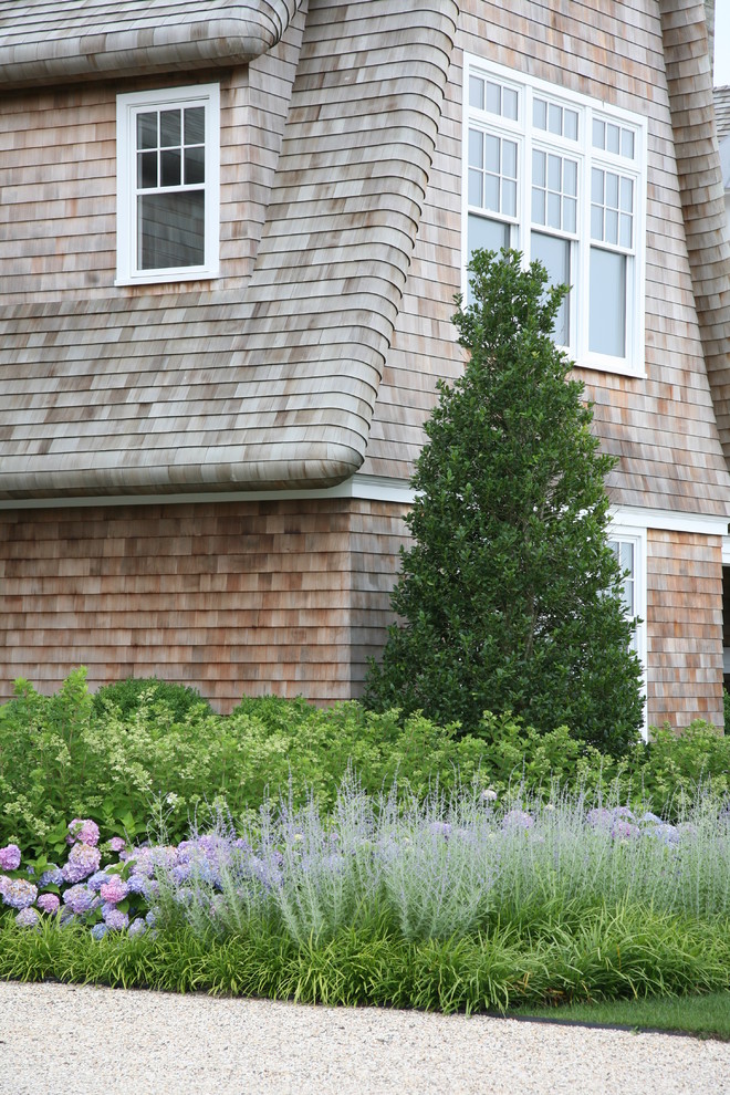 Foto de fachada de casa beige marinera de dos plantas con revestimiento de madera