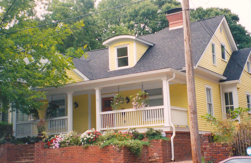 Diseño de fachada amarilla de estilo americano de tamaño medio de dos plantas con revestimiento de madera y tejado a dos aguas