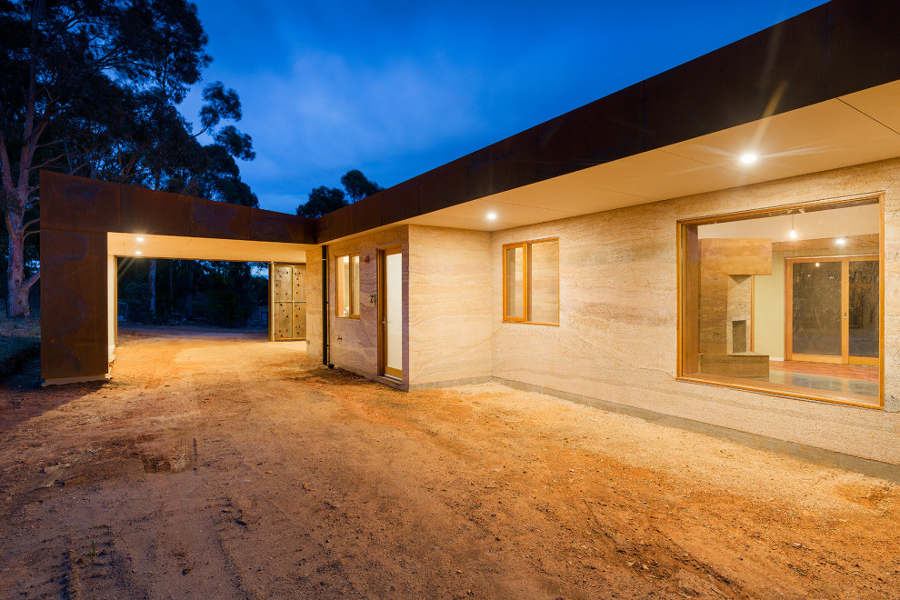 Immagine della villa beige contemporanea a un piano di medie dimensioni con rivestimento in adobe, tetto piano e copertura in metallo o lamiera