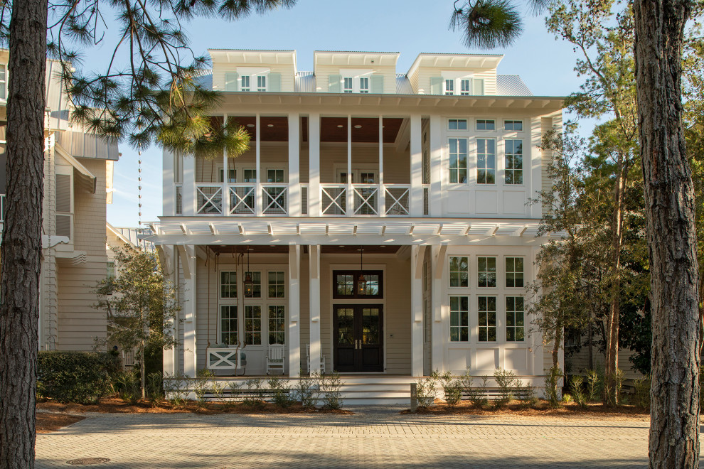Ejemplo de fachada de casa beige marinera grande de dos plantas con revestimientos combinados