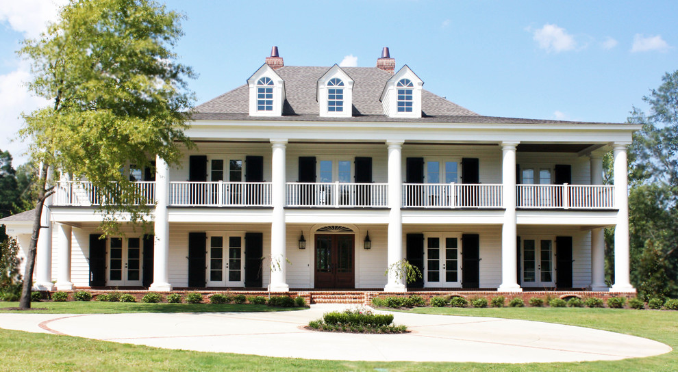 Modelo de fachada blanca clásica de dos plantas con tejado a cuatro aguas y revestimiento de vinilo