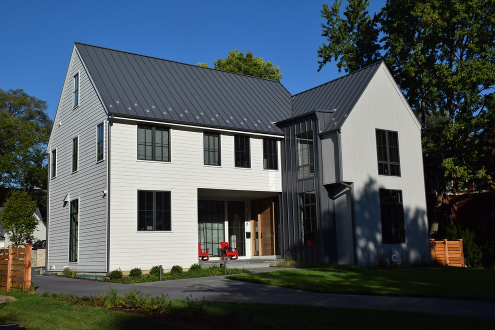 Modelo de fachada de casa multicolor campestre grande de tres plantas con revestimiento de madera y tejado de metal