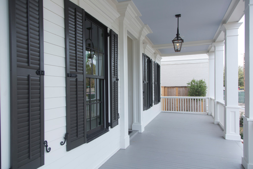 Photo of an expansive traditional front wood railing veranda in Houston with with columns and a roof extension.