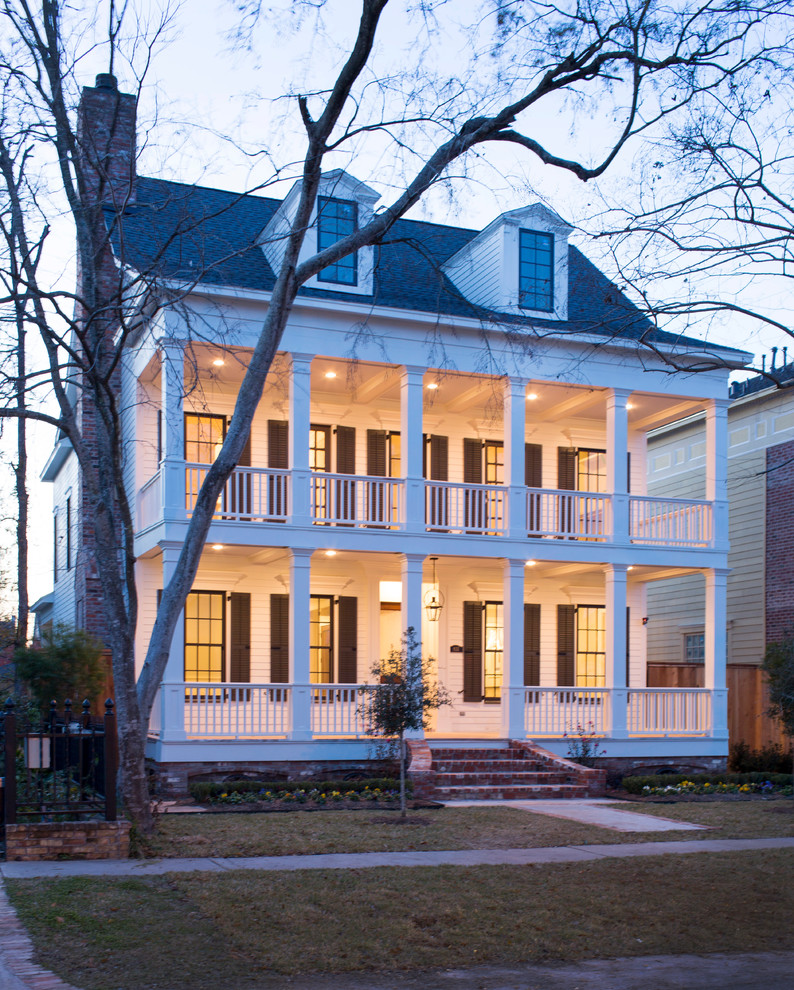 Foto della villa ampia bianca classica a due piani con copertura a scandole e tetto nero