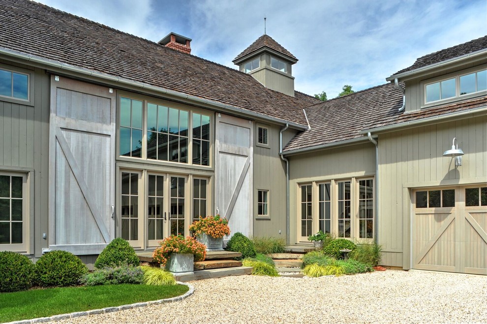 Modelo de fachada de casa gris campestre grande de dos plantas con revestimiento de madera, tejado a dos aguas y tejado de teja de madera