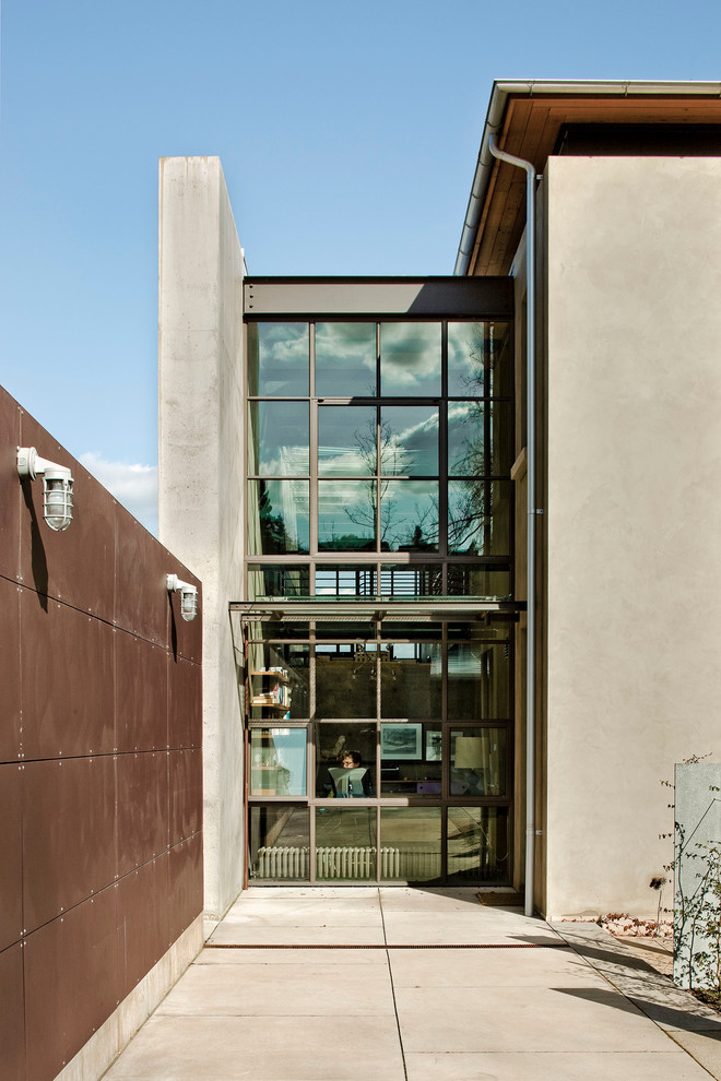 Esempio della facciata di una casa industriale con rivestimento in vetro e tetto piano