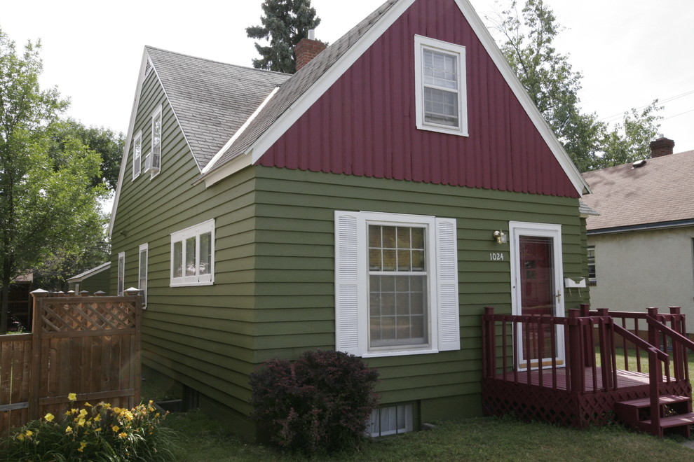 Esempio della villa piccola multicolore classica a due piani con rivestimento in legno, tetto a capanna e copertura a scandole