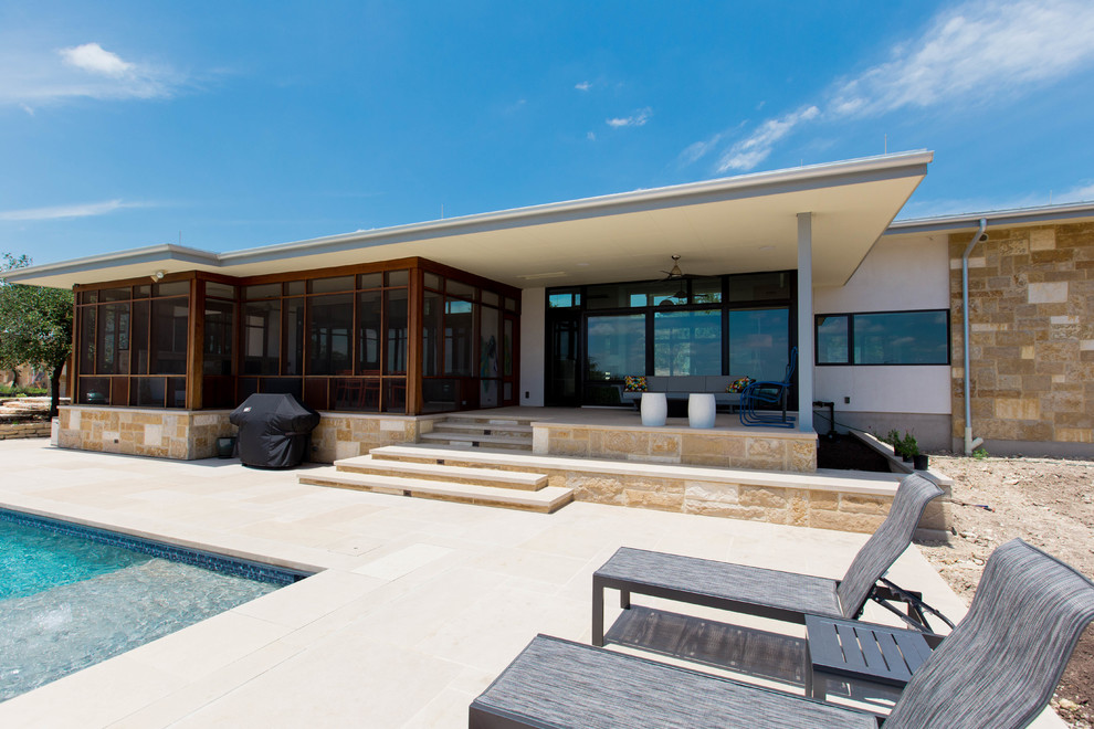 Cette image montre une grande façade de maison minimaliste de plain-pied avec un revêtement mixte et un toit en métal.
