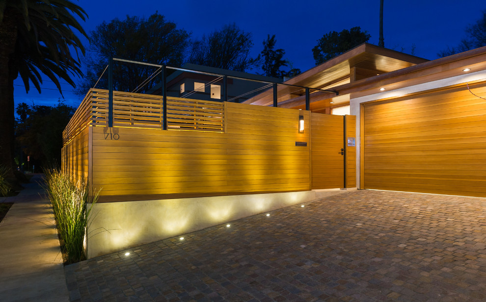 Medium sized and brown modern bungalow house exterior in Los Angeles with wood cladding.
