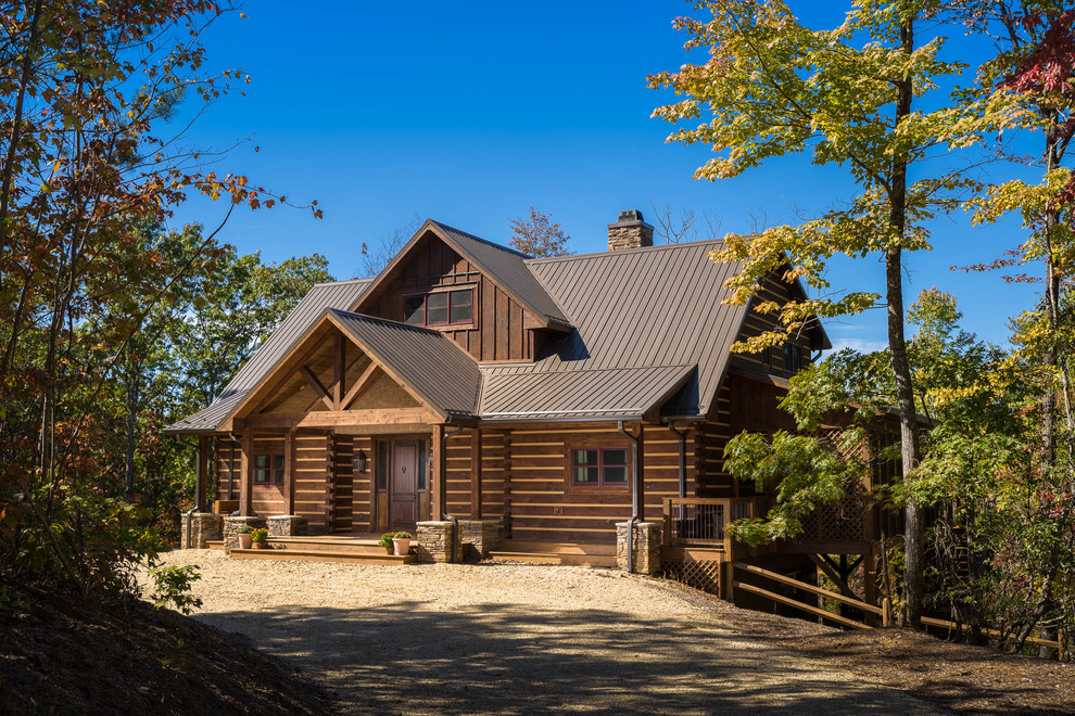 Inspiration pour une façade de maison marron chalet en bois à un étage avec un toit à deux pans et un toit en métal.