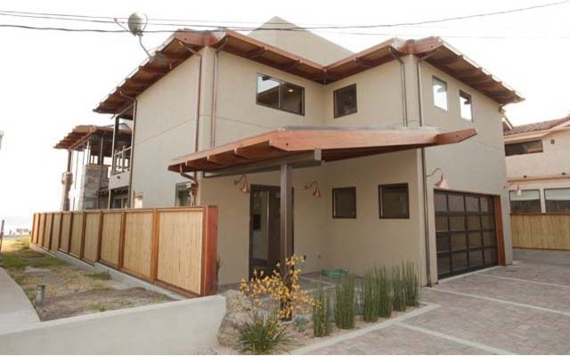 Стильный дизайн: двухэтажный, бежевый дом среднего размера в современном стиле с облицовкой из цементной штукатурки и плоской крышей - последний тренд