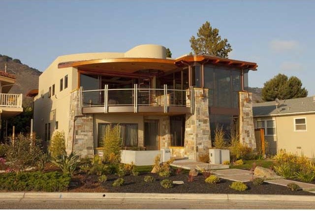 Ejemplo de fachada marrón contemporánea de tamaño medio de dos plantas con revestimiento de piedra y tejado plano