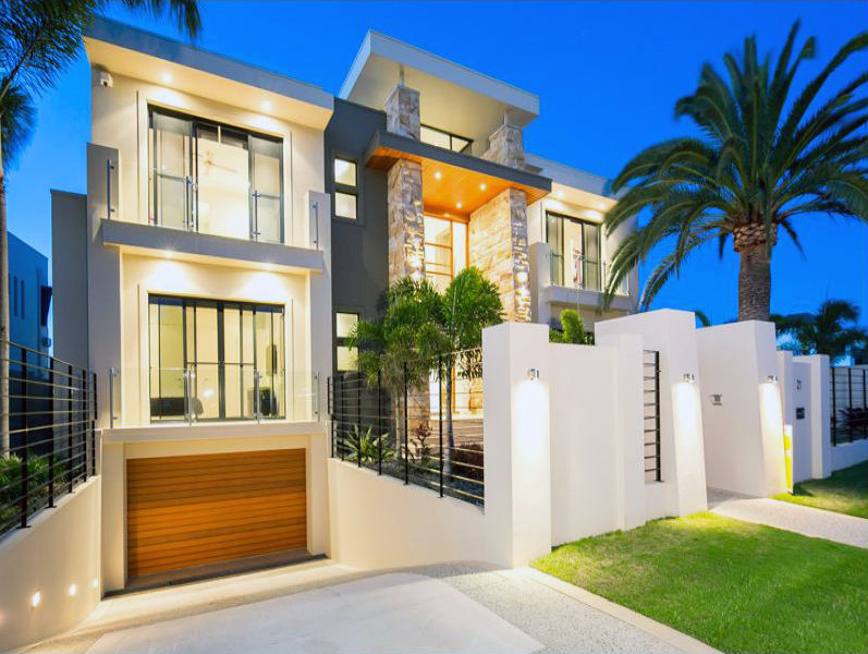Photo of a large and beige modern detached house in Gold Coast - Tweed with three floors, stone cladding, a flat roof and a metal roof.