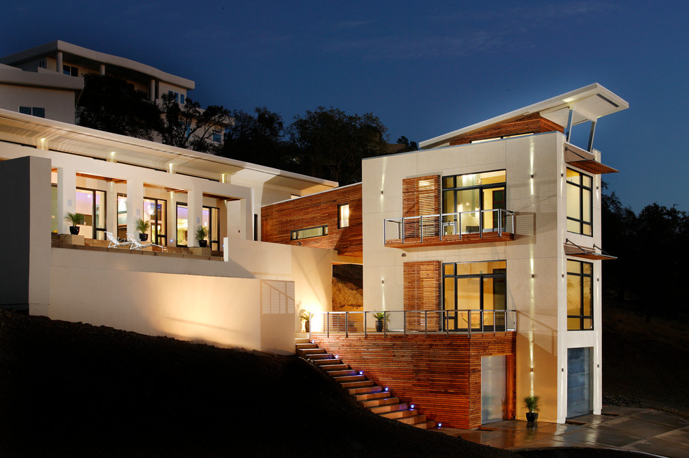 Ispirazione per la facciata di una casa contemporanea con rivestimento in legno e terreno in pendenza