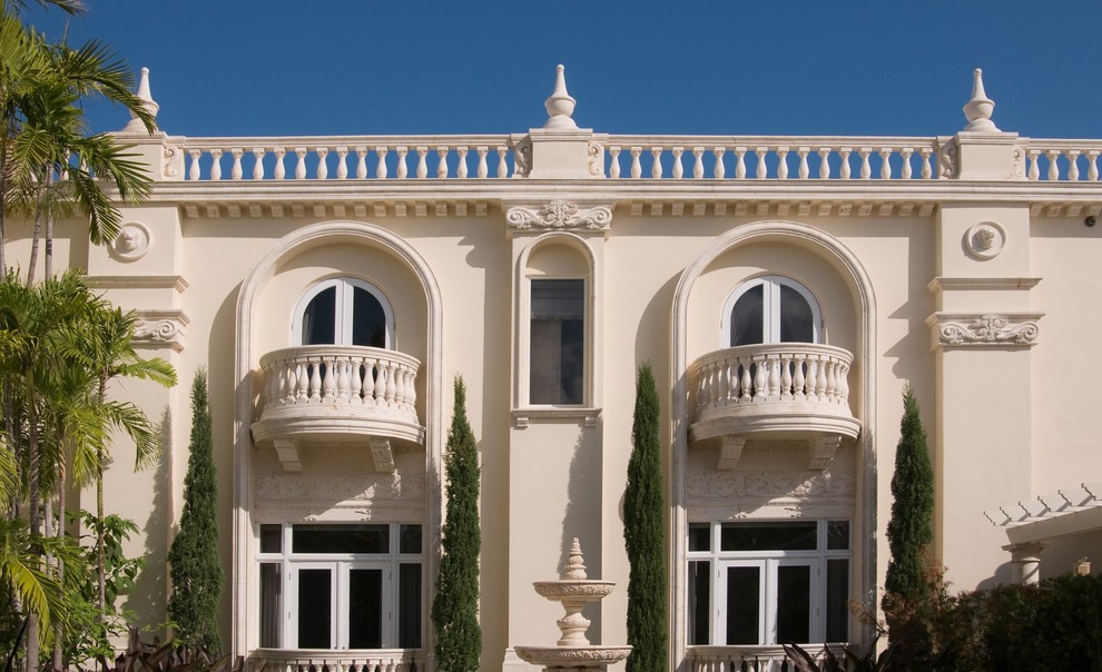 Foto de fachada beige clásica grande de dos plantas con revestimiento de estuco y tejado a dos aguas