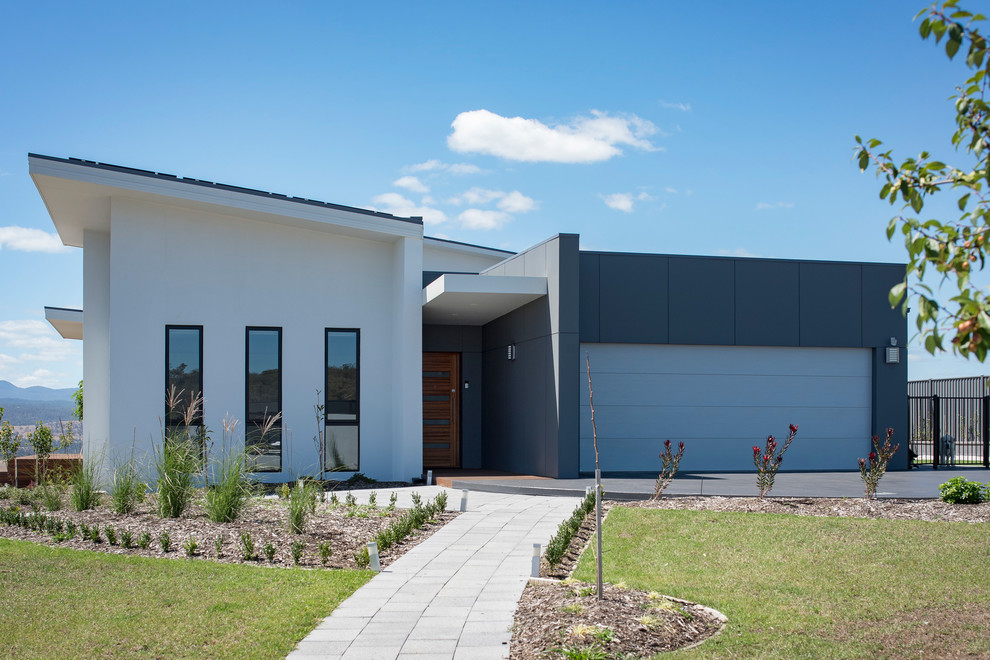 Cette image montre une façade de maison multicolore minimaliste avec un revêtement mixte et un toit en appentis.