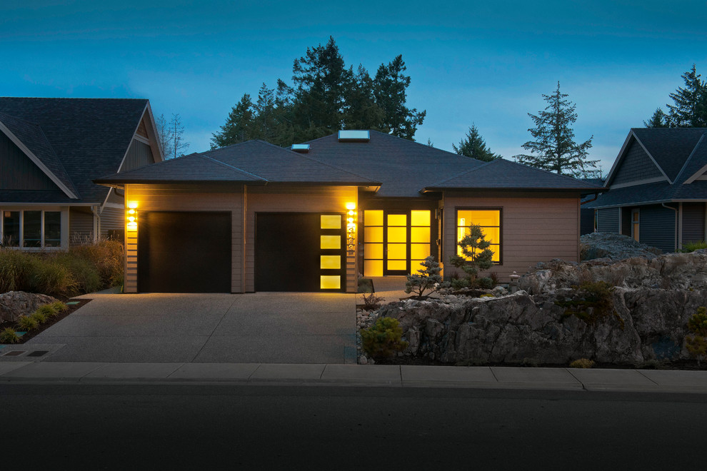This is an example of a medium sized and beige contemporary bungalow house exterior in Orange County with wood cladding and a hip roof.