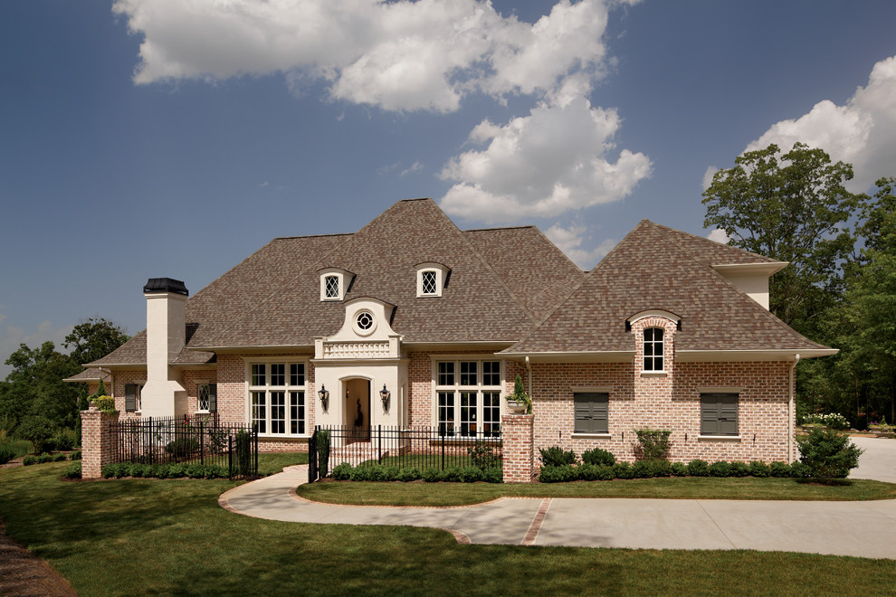 Inspiration for a timeless brown one-story brick house exterior remodel in Other with a shingle roof