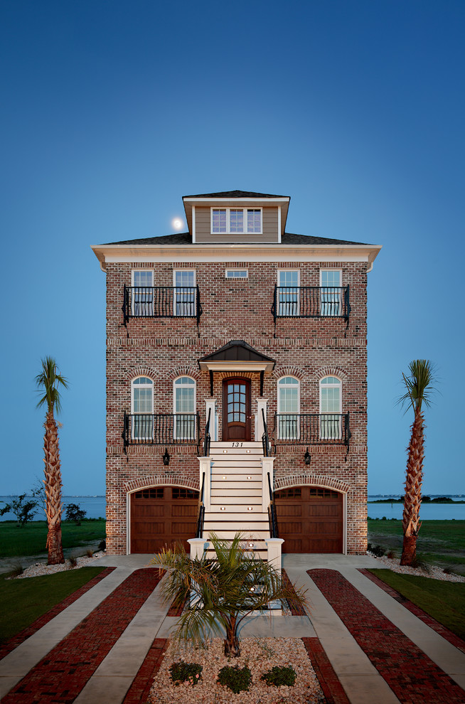 Esempio della villa grande marrone stile marinaro a tre piani con rivestimento in mattoni e copertura a scandole