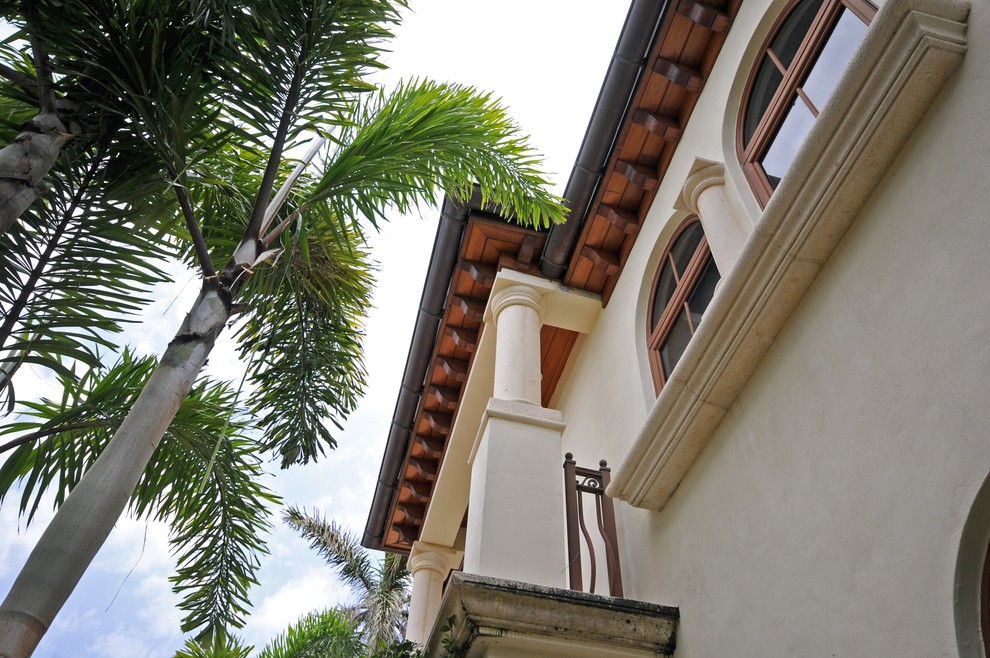 Foto della facciata di una casa grande bianca mediterranea a due piani con rivestimento in stucco e tetto piano
