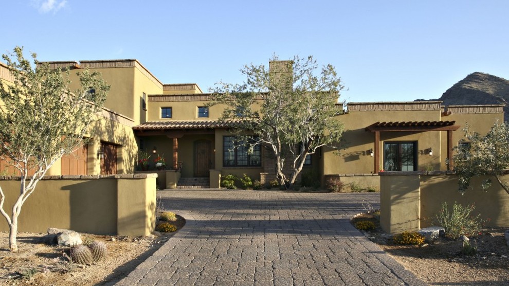 Example of a southwest green one-story adobe exterior home design in Phoenix