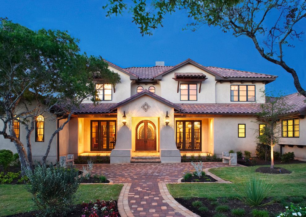 Huge mediterranean white two-story stucco exterior home idea in Austin with a tile roof