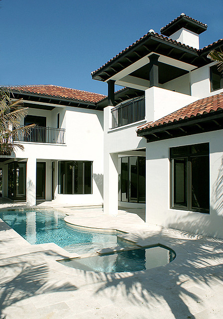 Large and white mediterranean render house exterior in Miami with three floors.