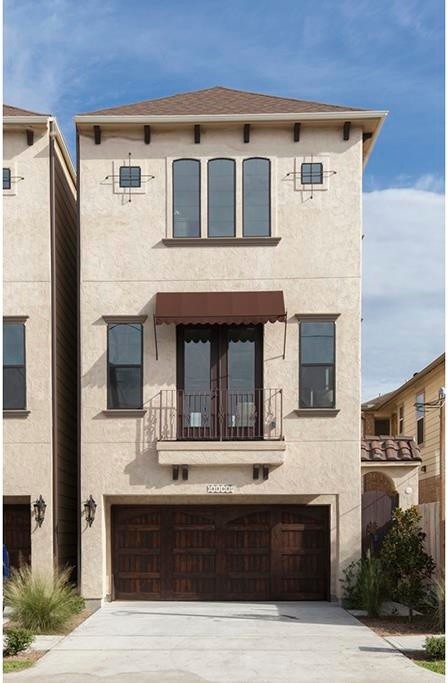 Design ideas for a beige mediterranean render house exterior in Houston with three floors.