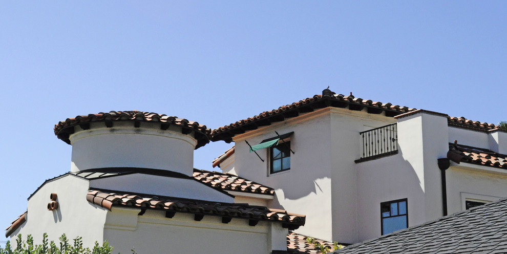 Example of a large tuscan white three-story stucco house exterior design in San Diego with a hip roof