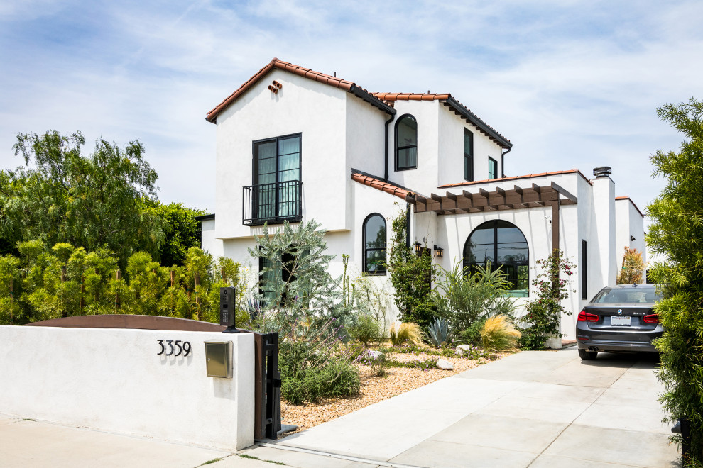 Mittelgroßes, Zweistöckiges Mediterranes Einfamilienhaus mit Putzfassade, weißer Fassadenfarbe, Satteldach und Ziegeldach in Los Angeles