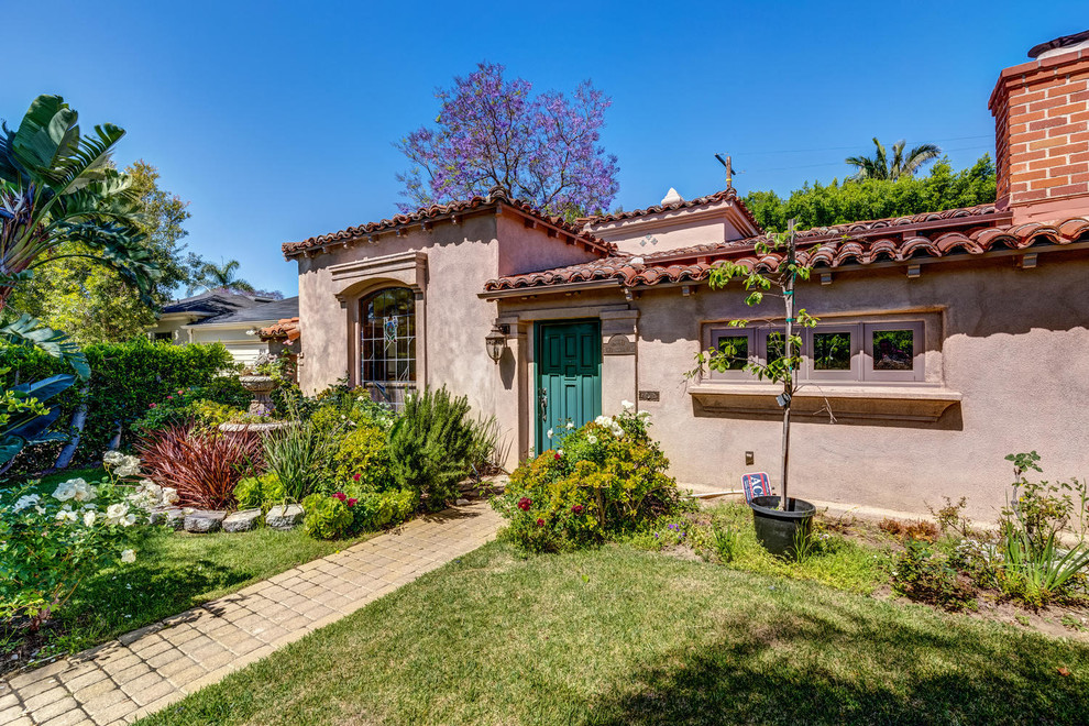 Medium sized and brown traditional bungalow render detached house in Los Angeles with a hip roof and a tiled roof.
