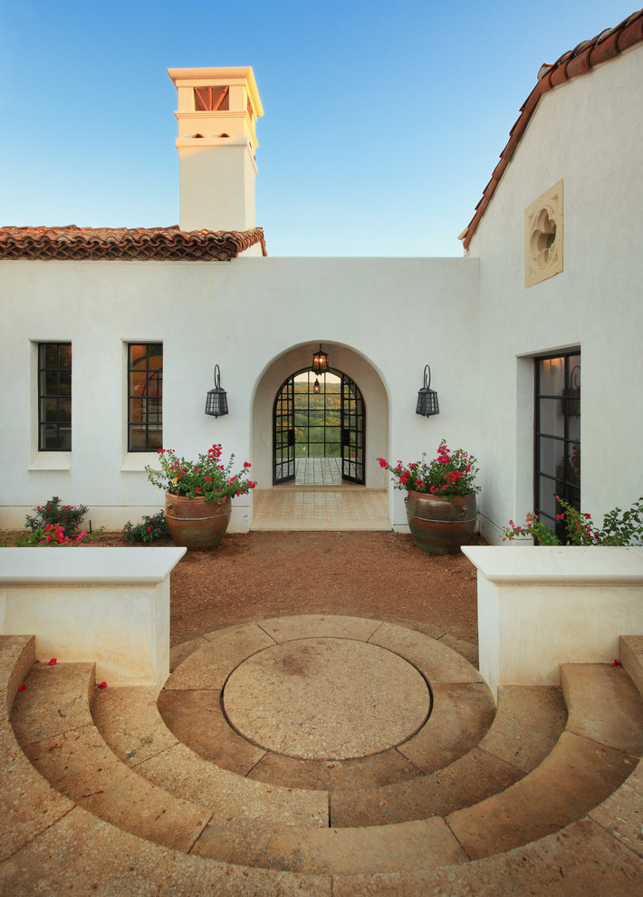 Example of a mid-sized tuscan one-story stucco exterior home design in Austin