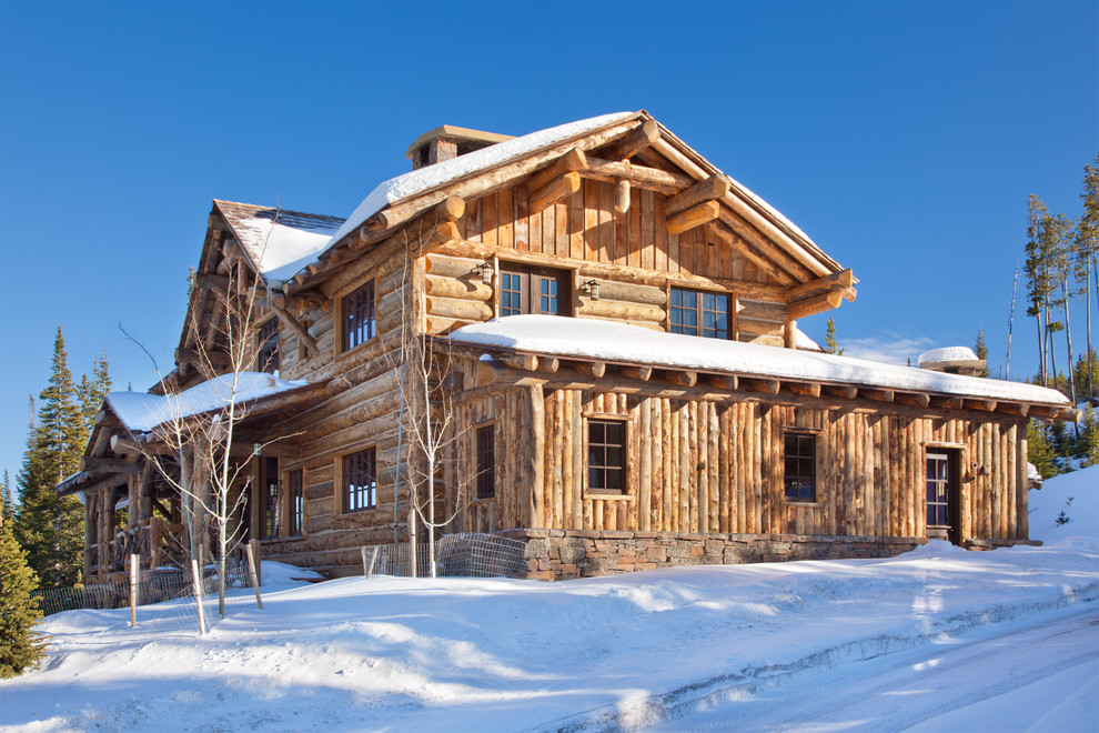 Photo of a rustic two floor house exterior in Other with wood cladding.