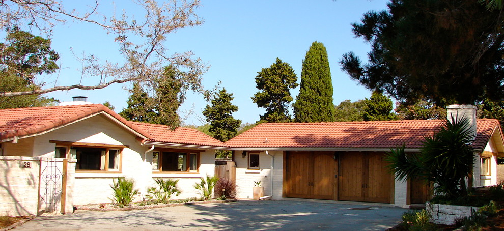 Modelo de fachada de casa blanca mediterránea de tamaño medio de una planta con revestimiento de adobe, tejado a dos aguas y tejado de teja de barro