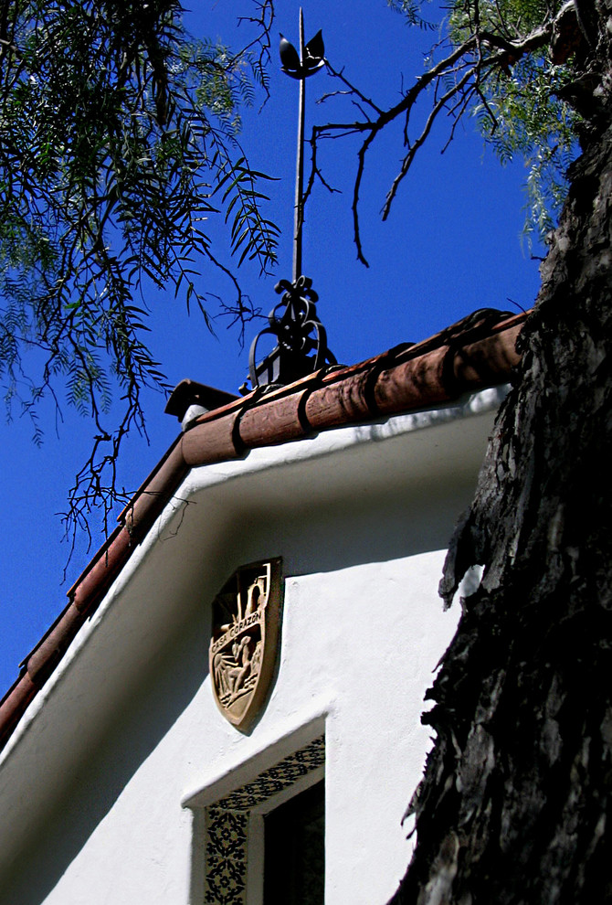 Modelo de fachada de casa blanca mediterránea de tamaño medio de una planta con revestimiento de estuco, tejado a la holandesa y tejado de teja de barro