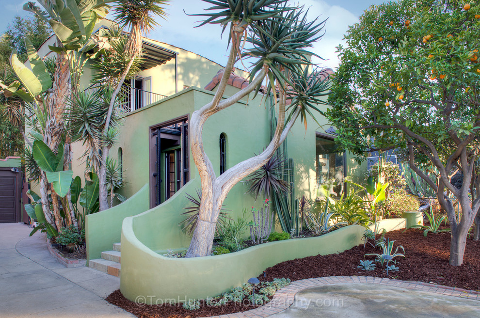 Mittelgroßes, Zweistöckiges Stilmix Haus mit Betonfassade und grüner Fassadenfarbe in Los Angeles