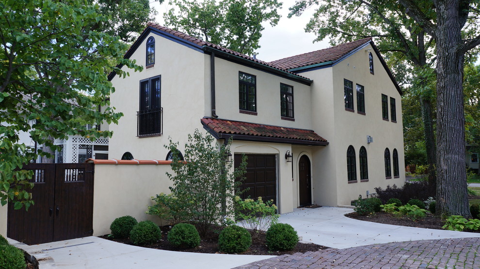 Inspiration for a medium sized and yellow mediterranean two floor render house exterior in Chicago with a pitched roof.
