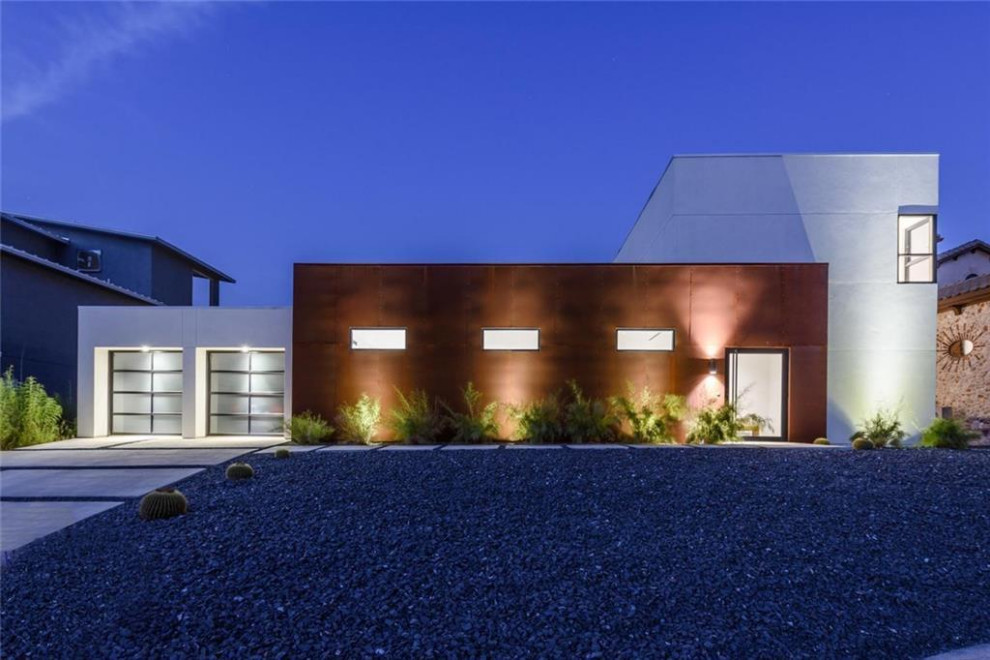 Cette photo montre une façade de maison métallique et blanche moderne à un étage avec un toit plat.