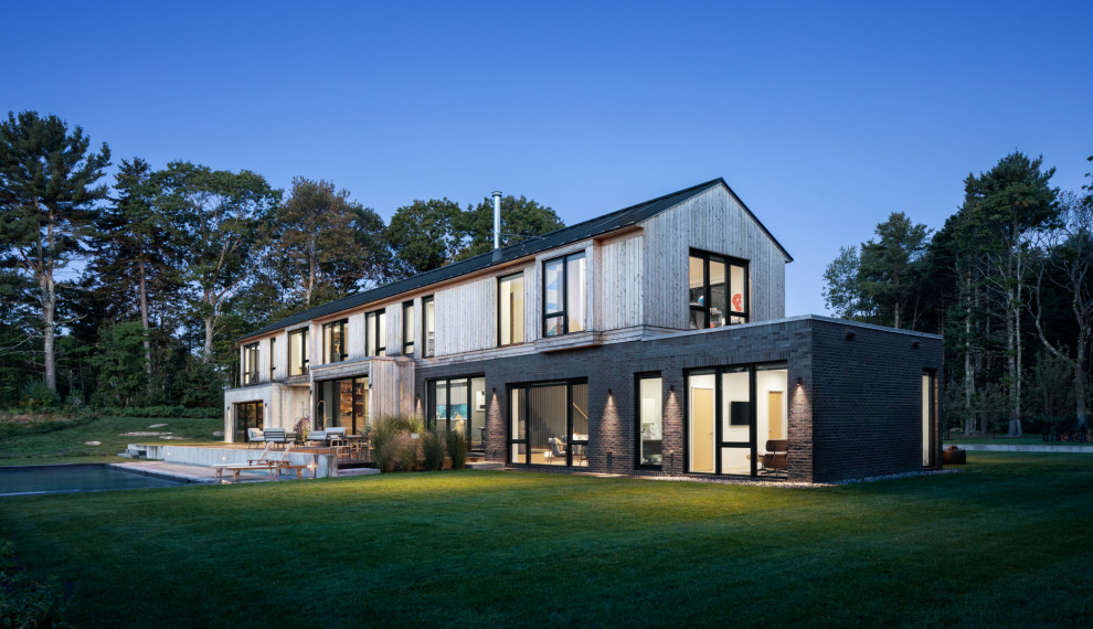 На фото: большой, двухэтажный, бежевый частный загородный дом в современном стиле с комбинированной облицовкой и металлической крышей с