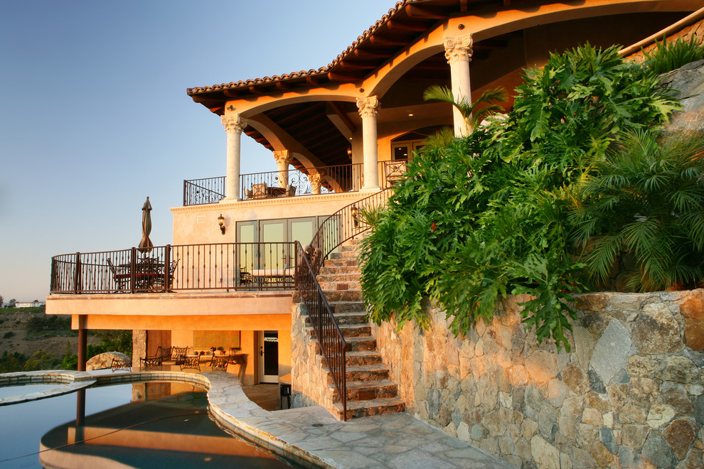 Immagine della facciata di una casa ampia beige mediterranea a tre piani con rivestimento in pietra